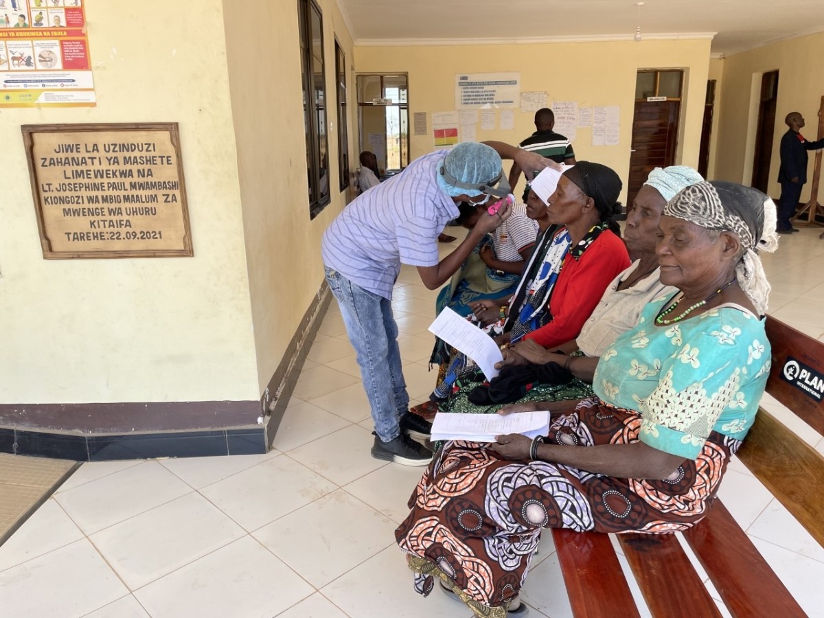 Patients being screened for blinding trachoma by a surgeon at an IMA World Health outreach site in western Tanzania.