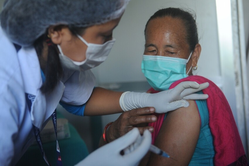 A nurse prepares to give a patient a COVID-19 vaccine shot in Nepal.