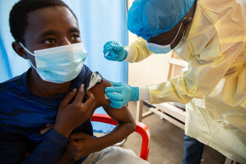A health care worker prepares to give man a vaccination shot in Goma, DRC.