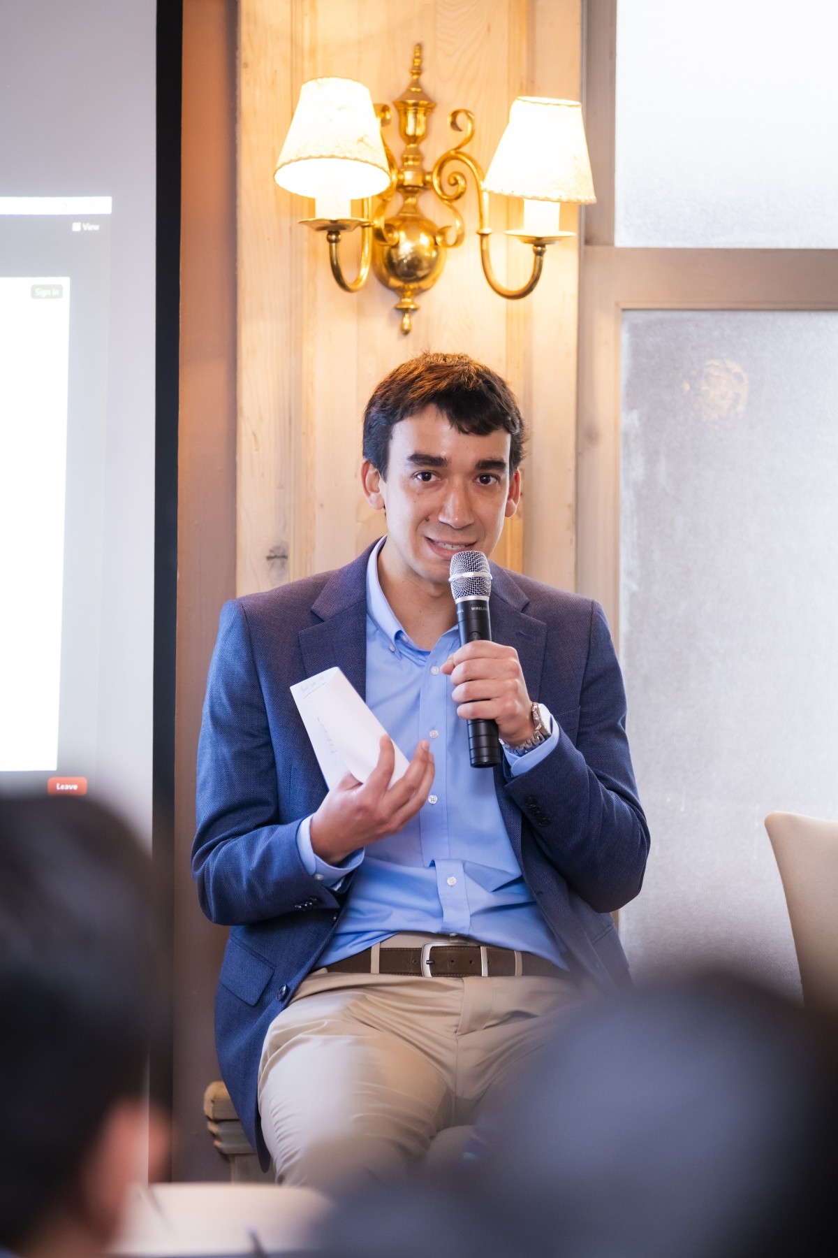 A man holds a microphone and speaks