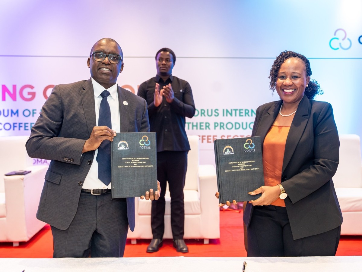 COPRA’s Director General Ms. Irene M. Mlola and Corus COO Mahmoud Bah hold up their signed copies of the MOU.